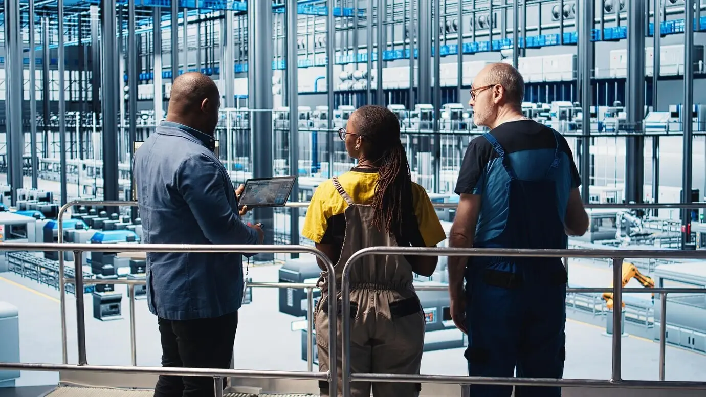 Manager beaufsichtigt Industrie-4.0-Werksmitarbeiter, die CAD-Software nutzen.